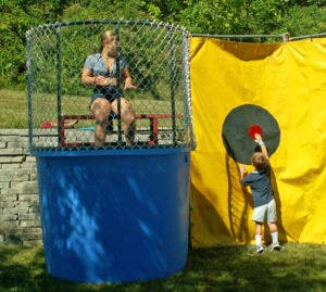 A kid cheats at a dunk tank fundraiser